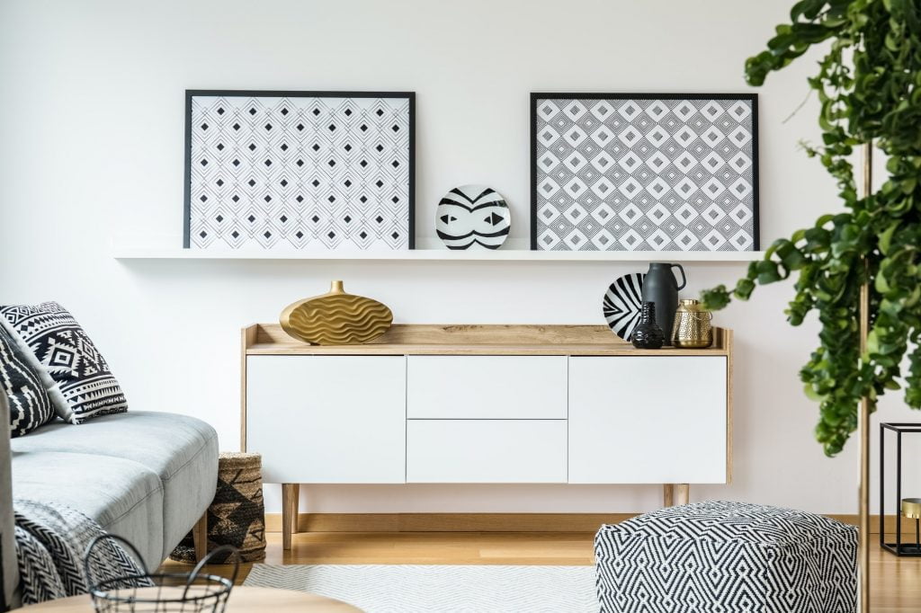 Patterned posters above cupboard in modern living room interior